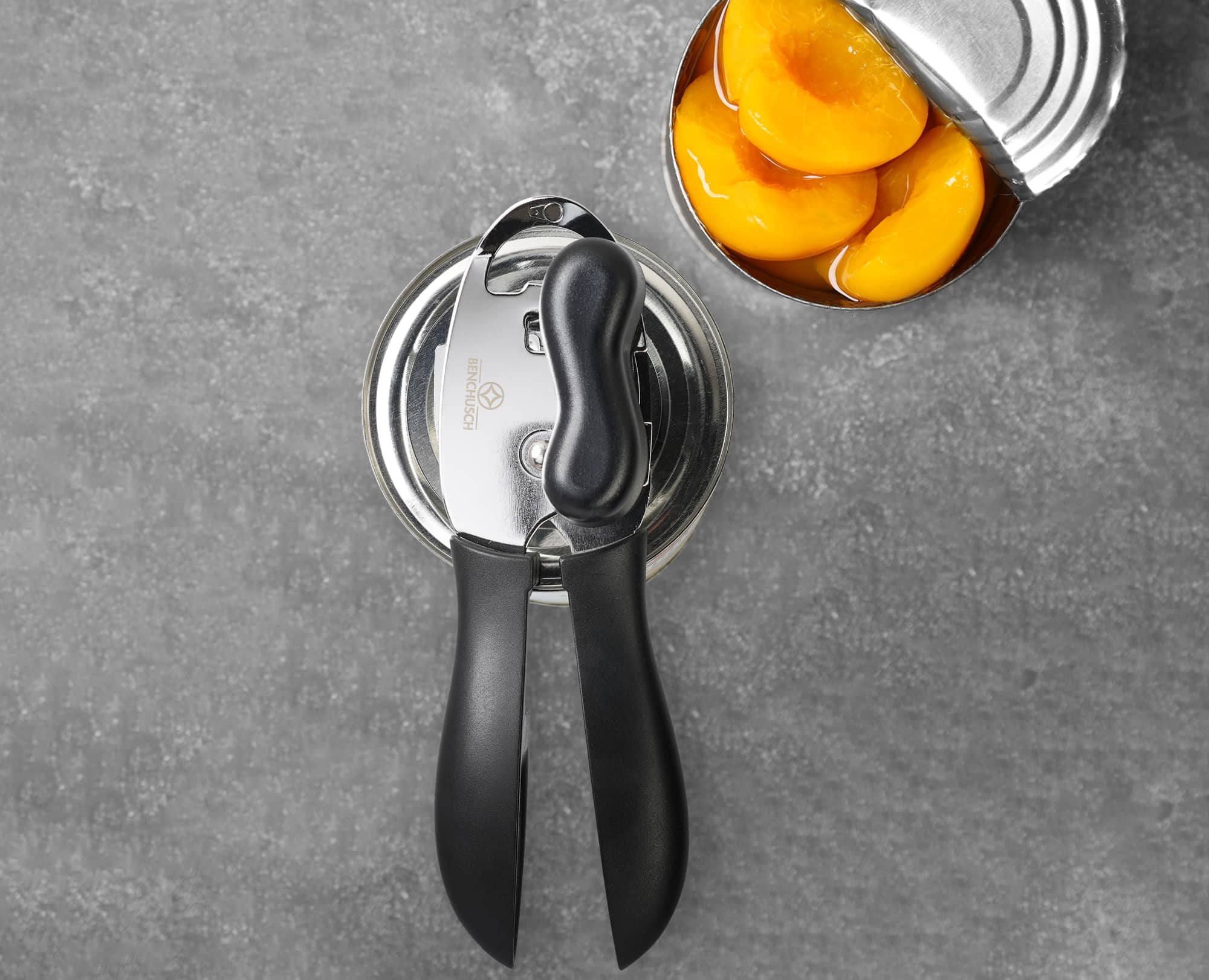 Benchusch Mordena Can Opener with Easy Turn Knob with canned peach opened on the dark background